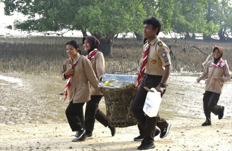 Foto: Anggota Saka Bahari bersama prajurit TNI Angkatan Laut membawa hasil pengumpulan sampah saat mengikuti aksi bersih pantai di kawasan Lapangan Tembak Cakra Kodaeral IV, Batam.