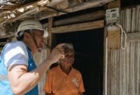 Foto: Petugas PLN memberikan penjelasan kepada seorang warga usai pemasangan sambungan listrik di rumahnya. Melalui Program Listrik Desa.