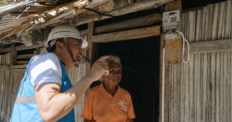 Foto: Petugas PLN memberikan penjelasan kepada seorang warga usai pemasangan sambungan listrik di rumahnya. Melalui Program Listrik Desa.