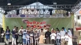 Foto: Panitia bersama tokoh masyarakat dan tamu undangan menyerahkan santunan kepada anak-anak yatim di atas panggung utama dalam rangkaian Gebyar Budaya Sunter Jaya Jilid 2 di Pulo Besar Elok, Kelurahan Sunter Jaya, Kecamatan Tanjung Priok, Jakarta Utara, Minggu (26/7/2026)