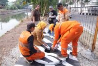 Foto: Petugas Penanganan Prasarana dan Sarana Umum (PPSU) bersama Lurah Kayu Putih, Tuti Sugihastuti, meninjau sekaligus mengisi biopori jumbo dengan sampah organik di RW 13, Kelurahan Kayu Putih, Kecamatan Pulogadung, Jakarta Timur, Rabu (29/7/2026).