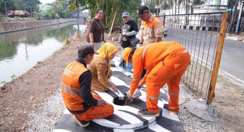 Foto: Petugas Penanganan Prasarana dan Sarana Umum (PPSU) bersama Lurah Kayu Putih, Tuti Sugihastuti, meninjau sekaligus mengisi biopori jumbo dengan sampah organik di RW 13, Kelurahan Kayu Putih, Kecamatan Pulogadung, Jakarta Timur, Rabu (29/7/2026).