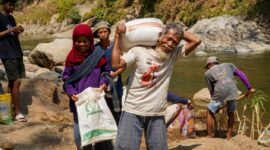 Foto: Seorang warga lanjut usia mengangkut karung berisi material bersama warga lainnya saat bergotong royong mendukung pembangunan Jembatan Garuda di Dusun Mojo, Desa Pucangombo, Kecamatan Tegalombo, Kabupaten Pacitan, Kamis (30/7/2026).
