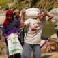 Foto: Seorang warga lanjut usia mengangkut karung berisi material bersama warga lainnya saat bergotong royong mendukung pembangunan Jembatan Garuda di Dusun Mojo, Desa Pucangombo, Kecamatan Tegalombo, Kabupaten Pacitan, Kamis (30/7/2026).