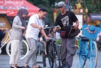 Pemilik sepeda onthel sewaan di kawasan Musium Fatahillah, Kota Tua Jakarta (kanan) sedang memberi penjelasan kepada wisatawan lokal yang akan menyewa sepedanya, pekan lalu. (Foto: herman wijaya)