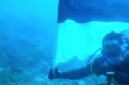 Foto: Romo Kolonel (Purn.) Sus. Yoseph Maria Marcelinus Bintoro, Pr., mengibarkan Bendera Merah Putih di bawah laut perairan Pulau Mimita, seberang Pulau Morotai, Maluku Utara, Senin (17/8/2026).