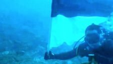 Foto: Romo Kolonel (Purn.) Sus. Yoseph Maria Marcelinus Bintoro, Pr., mengibarkan Bendera Merah Putih di bawah laut perairan Pulau Mimita, seberang Pulau Morotai, Maluku Utara, Senin (17/8/2026).