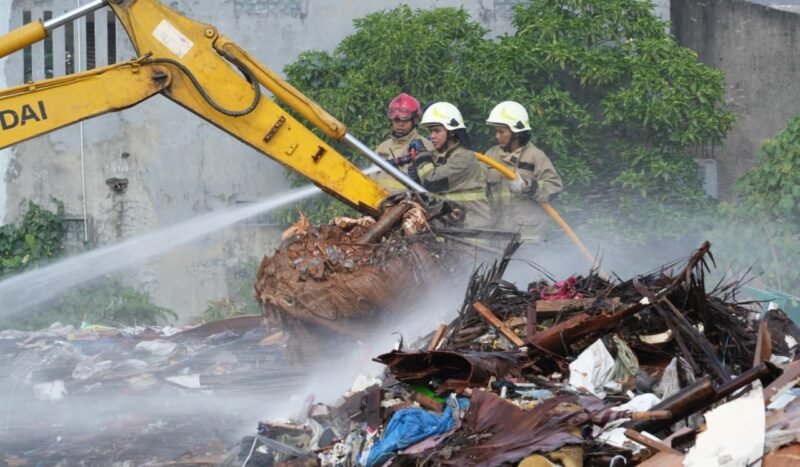 Foto: Petugas gabungan dari Dinas Penanggulangan Kebakaran dan Penyelamatan (Gulkarmat) DKI Jakarta melakukan proses pendinginan di lokasi kebakaran tumpukan sampah di Jalan Penggilingan Baru I, RW 03, Kelurahan Dukuh, Kecamatan Kramat Jati, Jakarta Timur, Minggu (2/8/2026).