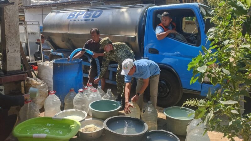 Foto: Petugas TNI bersama BPBD menyalurkan air bersih kepada warga terdampak kekeringan di wilayah Kecamatan Panggul, Kabupaten Trenggalek, Sabtu (8/8/2026).
