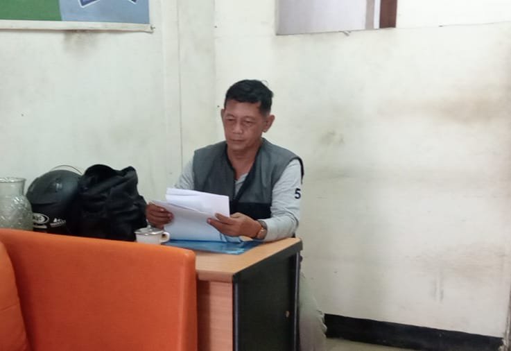 Foto: Seorang warga, Suwito, memeriksa sejumlah dokumen terkait laporan dugaan transaksi perbankan tanpa persetujuan yang mengakibatkan dana sekitar Rp273 juta berpindah dari rekeningnya.
