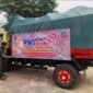 Foto: Seorang relawan memasang spanduk PWI Babel Peduli pada armada pengangkut logistik bantuan untuk korban kebakaran di Dusun Serdang, Desa Jelutung II, Kecamatan Simpang Rimba, Kabupaten Bangka Selatan, Selasa (13/10/2026).