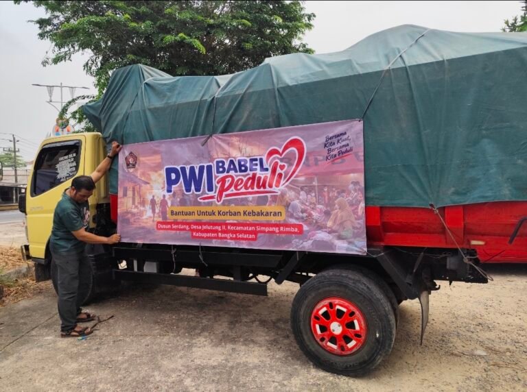 Foto: Seorang relawan memasang spanduk PWI Babel Peduli pada armada pengangkut logistik bantuan untuk korban kebakaran di Dusun Serdang, Desa Jelutung II, Kecamatan Simpang Rimba, Kabupaten Bangka Selatan, Selasa (13/10/2026).