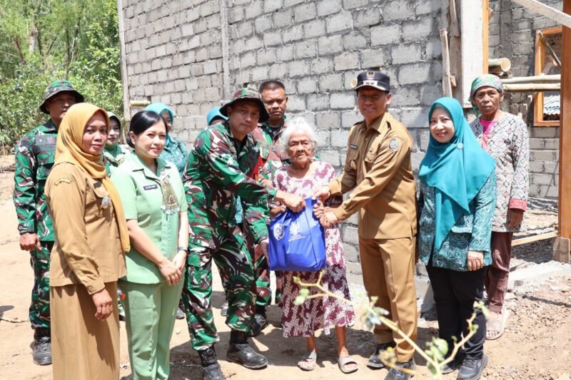 Foto: Satgas TMMD ke-130 Kodim 0807/Tulungagung bersama jajaran pemerintah daerah menyerahkan bantuan kepada Mbah Waqilah, 95 tahun, di depan rumahnya yang tengah direhabilitasi melalui program Rumah Tidak Layak Huni (RTLH) di Dusun Secang, Desa Pojok, Kecamatan Campurdarat, Kabupaten Tulungagung, Rabu (14/10/2026).