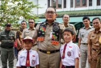 Foto: Wali Kota Administrasi Jakarta Pusat Arifin berfoto bersama dua siswa saat meninjau hasil revitalisasi gedung SDN Petojo Utara 01, Jakarta Pusat, Selasa (20/10/2026). 