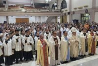 Foto: Ignatius Kardinal Suharyo bersama para imam dan pelayan liturgi berfoto bersama umat Katolik dari lingkungan TNI-Polri seusai perayaan misa di Gereja St. Martinus Lanud Dhomber, Balikpapan, Kalimantan Timur, Rabu (21/10/2026). 