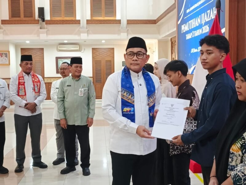 Foto: Wali Kota Administrasi Jakarta Pusat, Arifin, menyerahkan ijazah kepada salah satu penerima manfaat dalam kegiatan Pemutihan Ijazah Tahap II Tahun 2026 di Ruang Serbaguna Utama Kantor Wali Kota Jakarta Pusat, Kamis (29/10/2026).